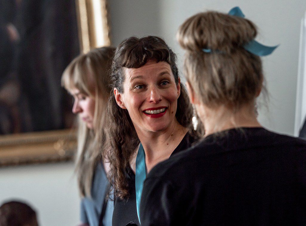 Naiset hymyilevät toisilleen