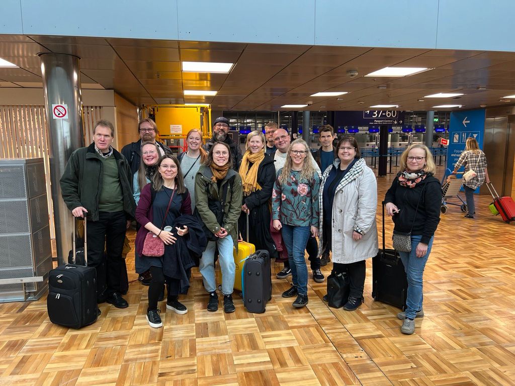 Kuorolaiset ryhmäkuvassa matkalaukkuineen Berliinin lentokentällä